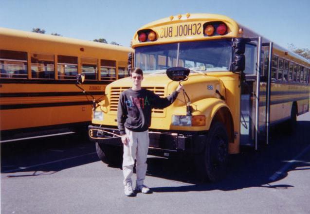 Matthew standing in front of a 1999 Bluebird International!